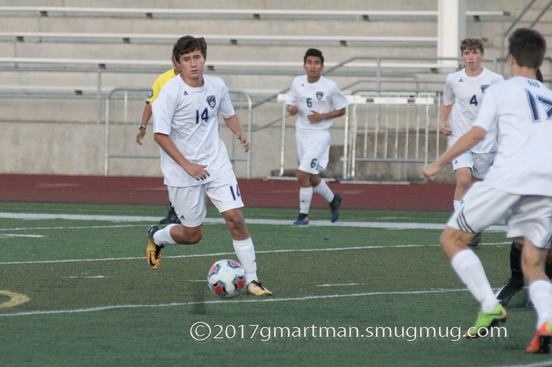 Sam Blohn dribbles the ball across the field looking for the open man