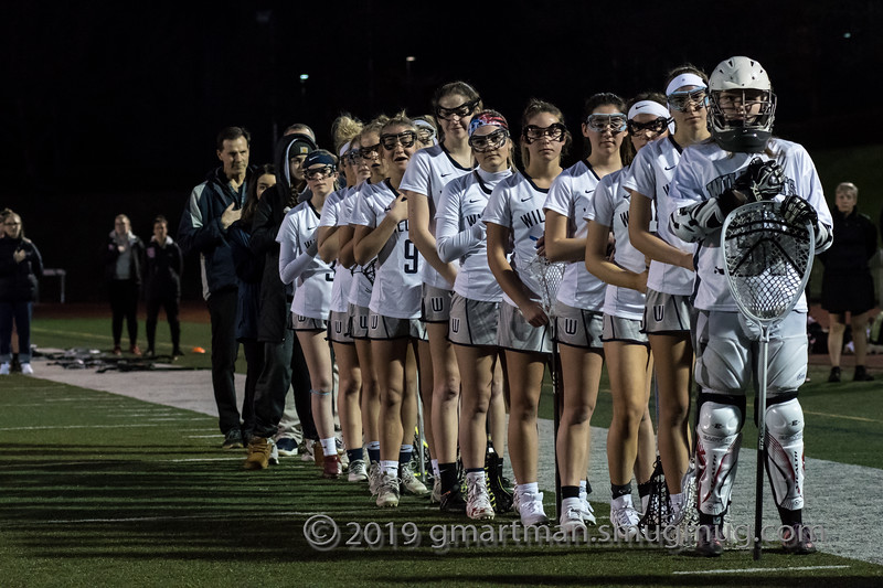 The girls LAX squad lines up for the national anthem earlier this season.  After a challenging pre-season, they captured the win against Oregon City.