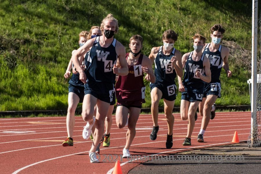 Distance Runners racing hard during the 1500m race. Coming around the curve of lap 3 led by Wilsonville. 