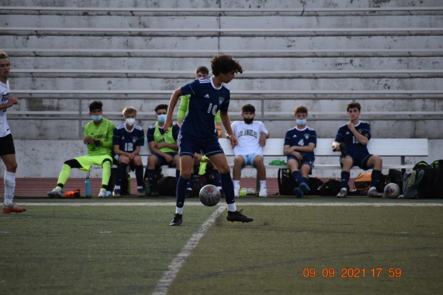 Junior Yaseen Mubashir controls the ball in front of his home bench.