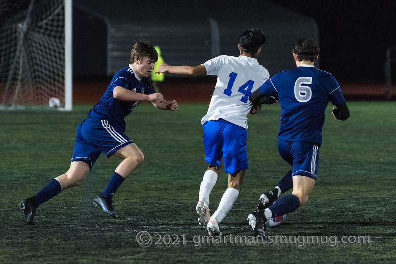 Cameron Little and Daniel Page fight for the ball with an opposing player.