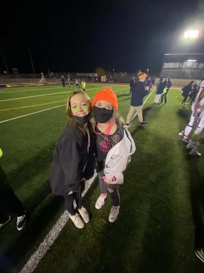 Ella Hubka and the author enjoying a football game, a common thing for high school students to do. The article examines whether kids should be kids or whether they should be looking forward to the adult world.