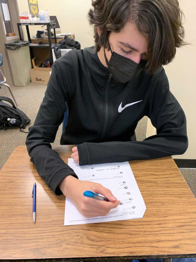 Sophomore Connor Larsen doing math homework during journalism. He has cross country after school and doesn’t have a lot of time to get homework done.