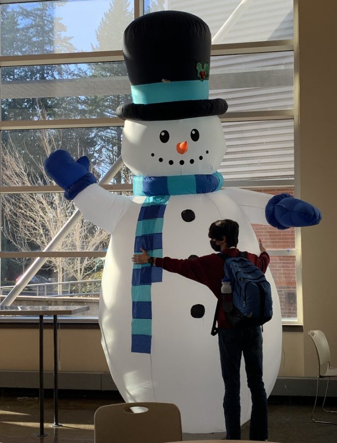 Connor Larsen hugs the inflatable snowman that made an appearance at the pointe this winter season. The Leadership team makes sure to put up decorations for lots of holidays. 