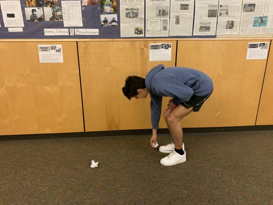 connor Larsen picks up trash from the floor. Even though he didnt make the mess he still picks it up.