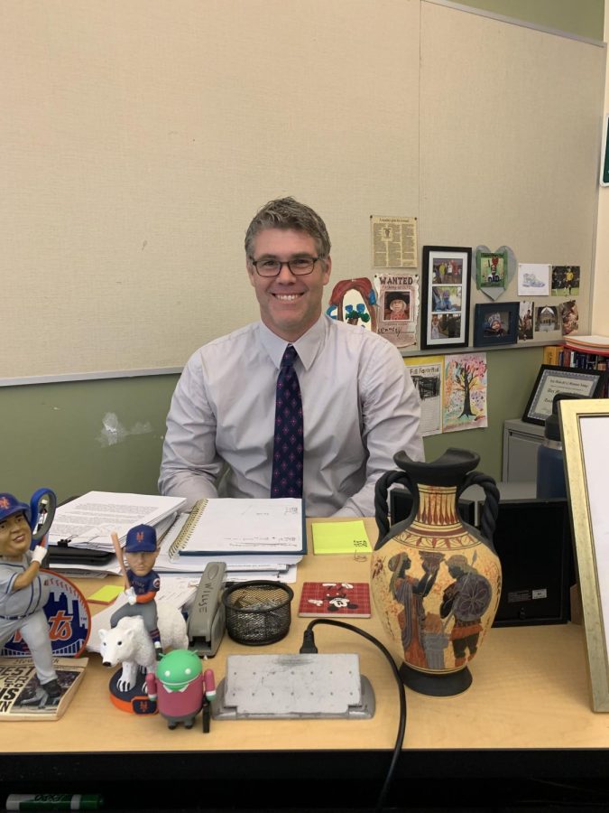 Mr. Willse sits at his desk in room 127. This year his job title is Social Studies teacher. 