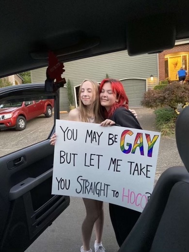 Juniors Aida Simonton and Grace Teekee pose with their sign. No matter the exact manner of the proposal, signs are popular methods among WVHS students.