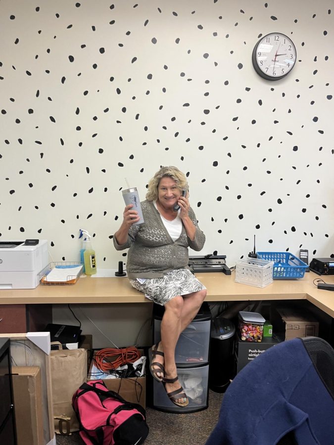 Ms. Gunter poses in her office. She likes the fun wall that is a feature of the space!