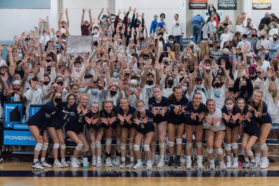 Wilsonville+Volleyball+and+the+student+section+holding+up+Ws+for+a+picture.+Wilsonville+is+undefeated+and+continues+to+dominate+the+court.+