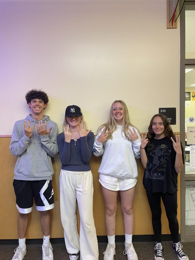 Freshman Ryan Williams, sophomore Lily Arzie, junior Maddie Holly, and senior Hannah Aldrich wear their class colors and their graduating year.