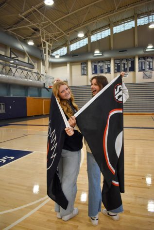 Helena Jones and Makenna Weipert pose with their future schools’ flags. (Part 2/2)