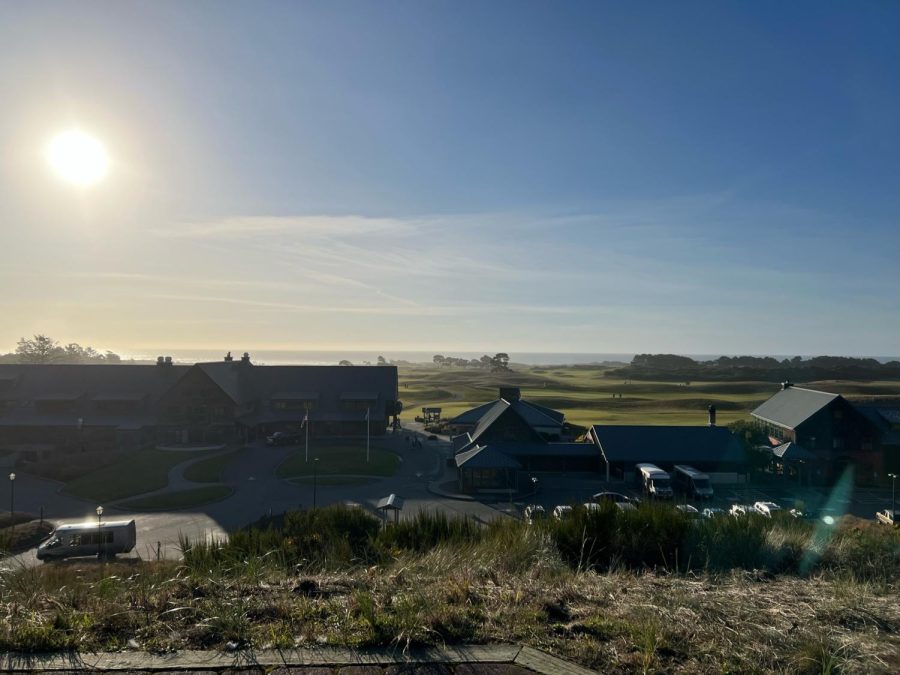 A sophomore student looks beyond the Bandon Dunes Golf Resort. The ocean creeps through the depths of the golf course, as the sun. begins to set.