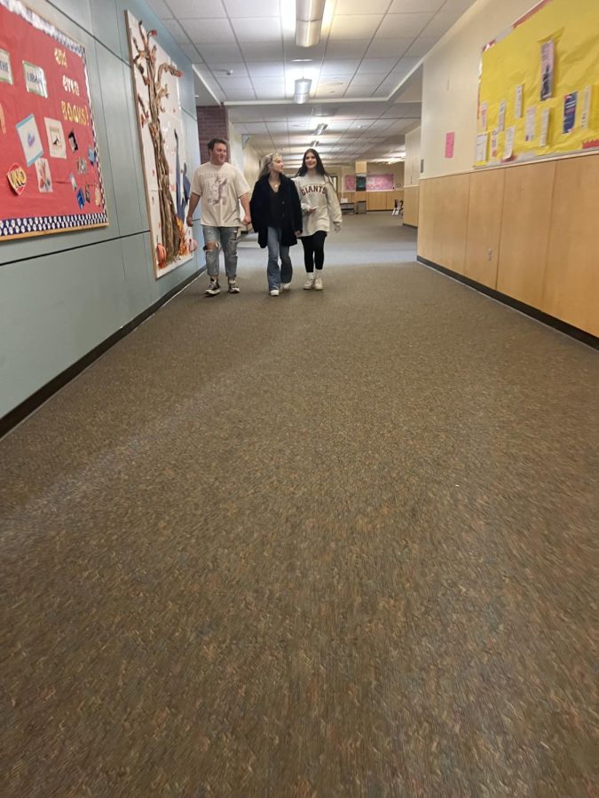Three students taking a lap around the school as a break from their sixth period class.