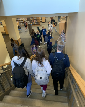 Students walk three abreast down the stairs, blocking off their fellow escapees. 