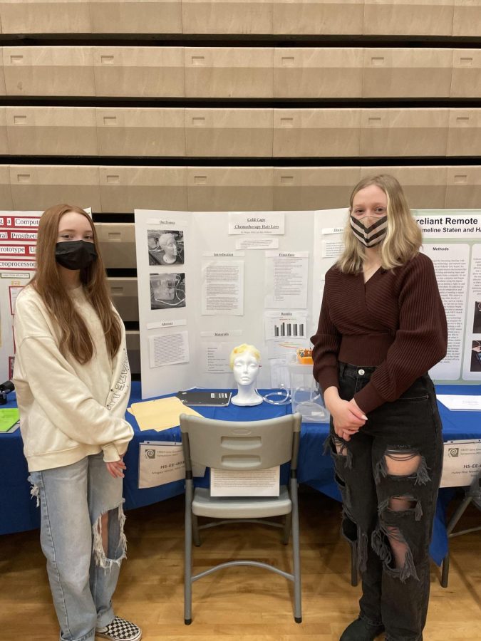 Megan Whitt and Mia Williams stand in front of their science fair display, ready to present!