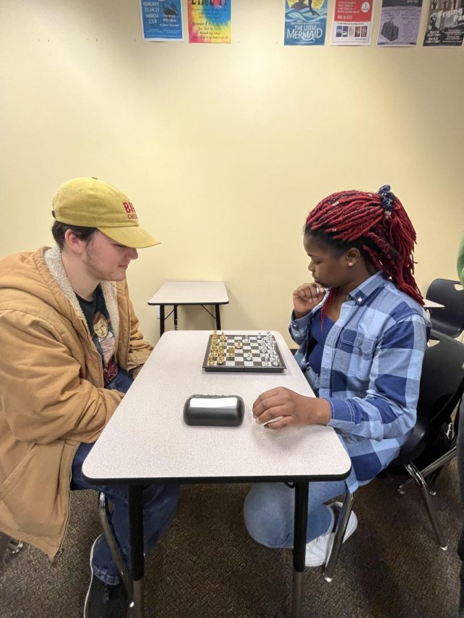 Venelle Imbi, a follower of chess, battles her opponent, Xavier Nelson.  The photo visualizes the silent intensity of a match.