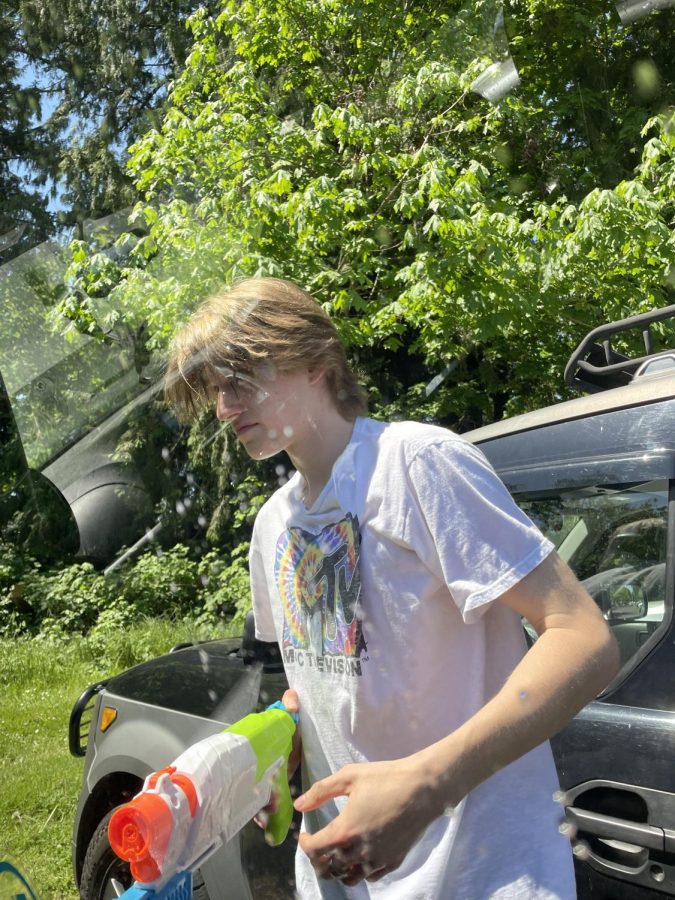 Grant Carli, Senior, is shown here with a super soaker. Although Carli did not play the game, he still took part in helping people with  their targets and spraying water on passerby.