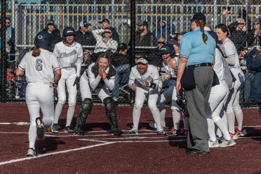 Junior Mary Matthews meets her teammates at home after she hit her second homerun of the game. Wilsonville came away with a 10-1 win against the Canby Cougars. 