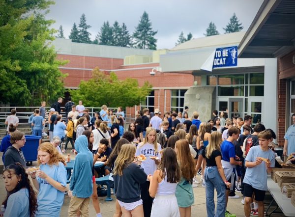 Above, hundreds of incoming freshmen gather outside Wilsonville High School after orientation to celebrate
 the coming year with pizza. 