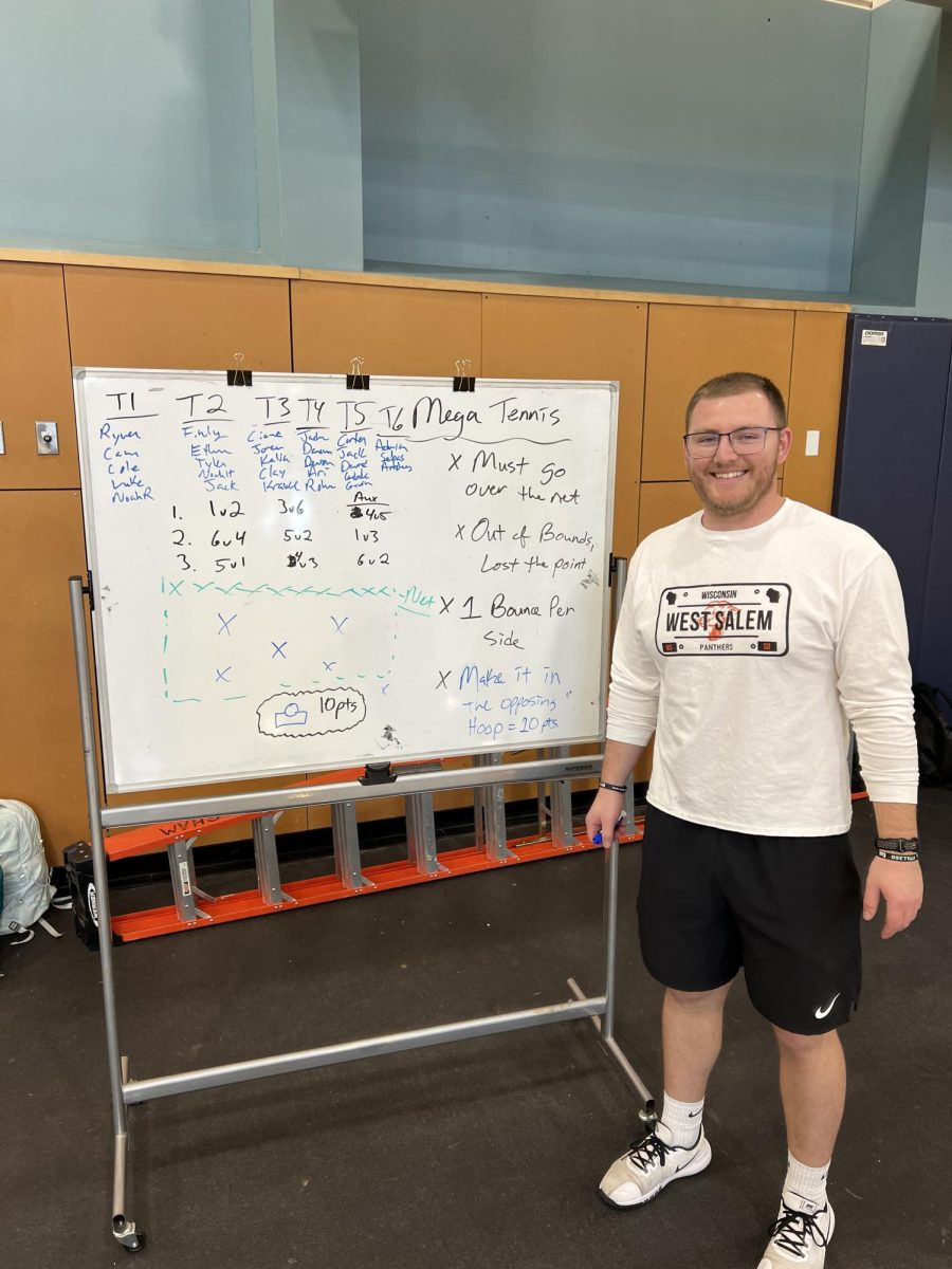 1st year teacher at WVHS - Mr. Krause stands next to whiteboard with teams and rules of the game. Mr. Krause joins us after time previously spent in Wisconsin. 