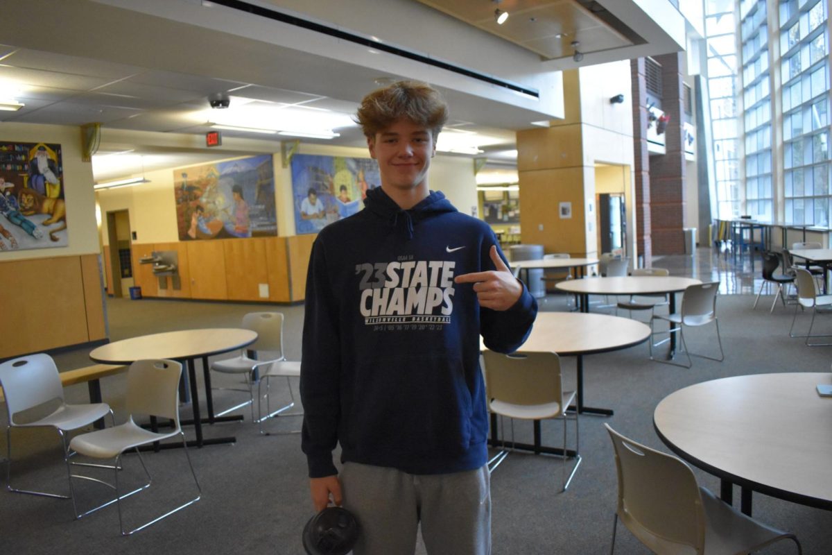 Junior, Jacob Boss points to his Wilsonville Basketball sweatshirt. The Wildcats Basketball program took home the Oregon 5A State Championship last year.
