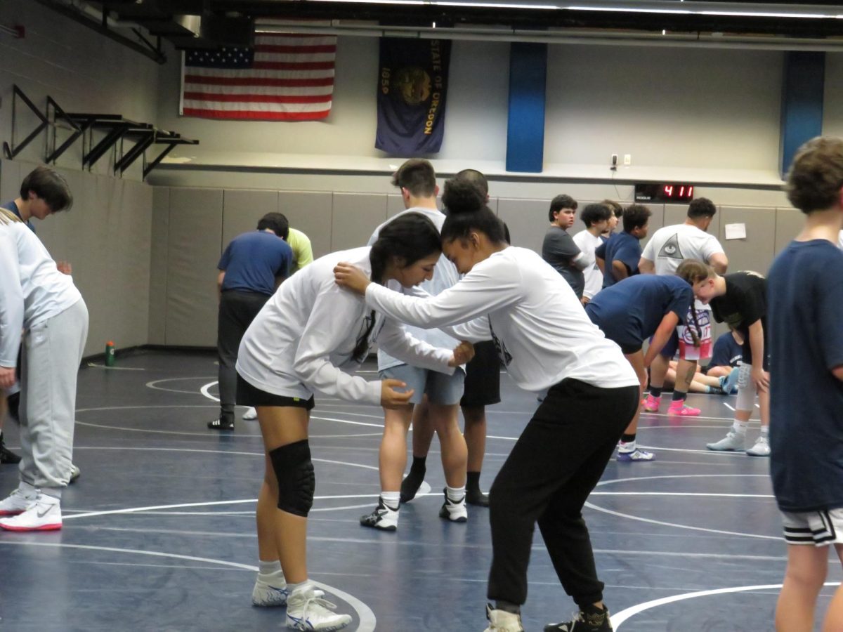 Isabella Quesada warms up with her partner before practice. Quesada is one of three female wrestlers who qualified for the 2024 6A/5A State Championships. 