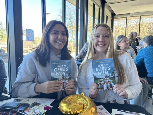 Sophomore Fareeda ElManhawy and senior Maddie Holly pose with George Fox Women’s Golf coach Maryjo McCloskey’s book “When Girls Win”. This was the first ever celebration for Title IX and National Girls and Women in Sports Day hosted by the OSAA. 