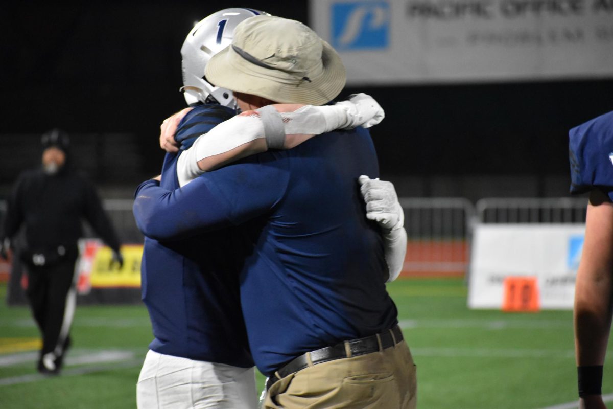 Junior+Mark+Wiepert+shares+a+hug+with+head+coach+Adam+Guenther+after+winning+the+5A+Football+State+Championship.+Guenther+is+one+of+the+most+universally+loved+coaches+and+created+an+immense+amount+of+success+for+his+team.