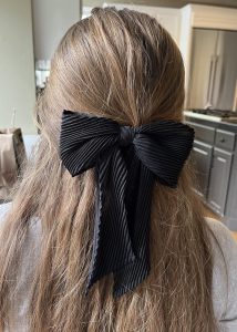 Sophia Levesque wears a black bow in her hair. She owns many different bows that she loves to wear! 