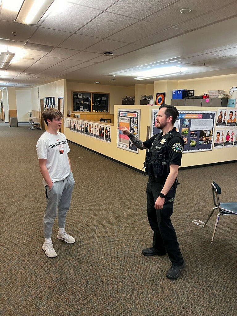 Sophomore+Oliver+Latta+encounters+campus+officer+Zach.+While+maybe+the+most+obvious+person+looking+out+for+Wilsonville+High+School%2C+Officer+Zach+is+not+the+only+administrator+monitoring+hallway+behavior+and+classroom+respect.+Wilsonville+is+lucky+to+be+a+safe+space+for+hundreds+of+students.+