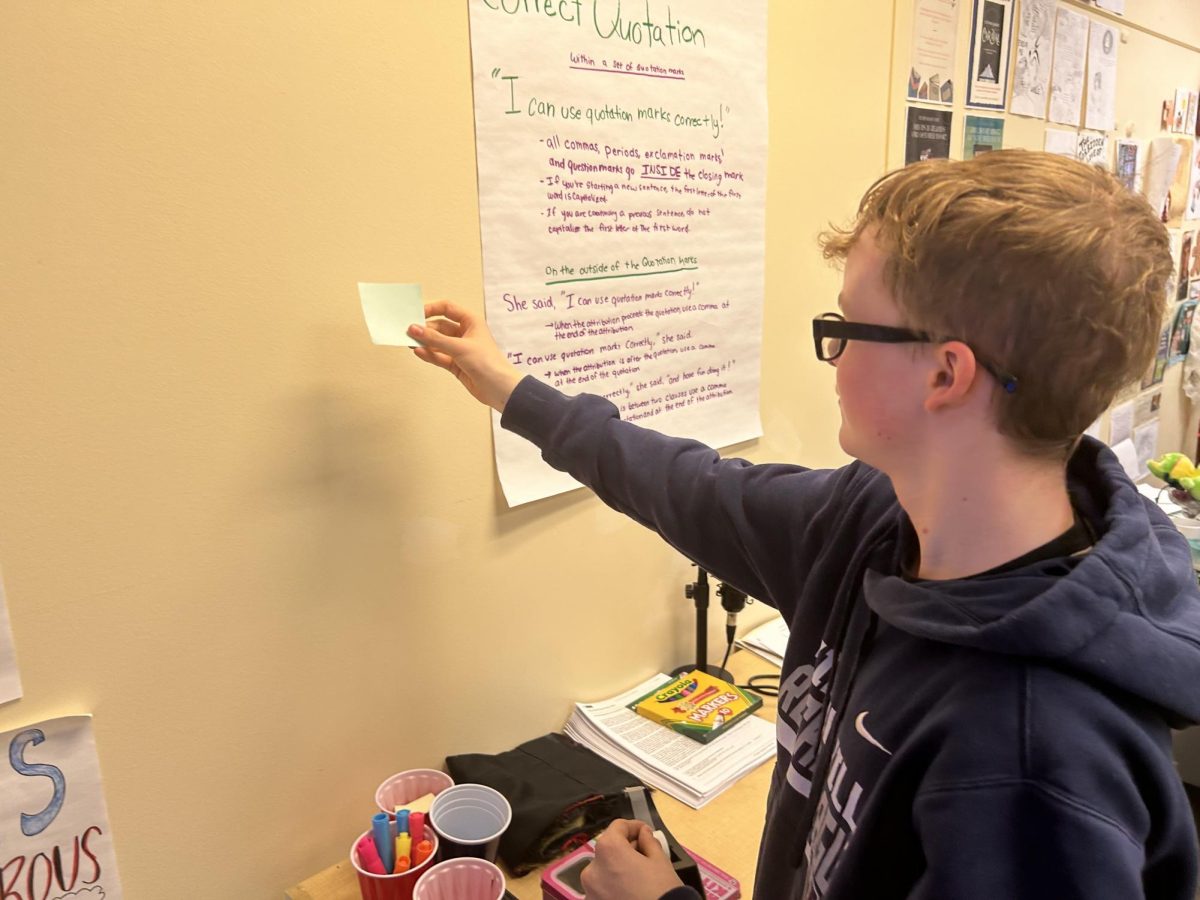 Freshman student puts sticky note on wall like done in scavenger hunts, one of the most common ways teachers bring movement into the classroom.