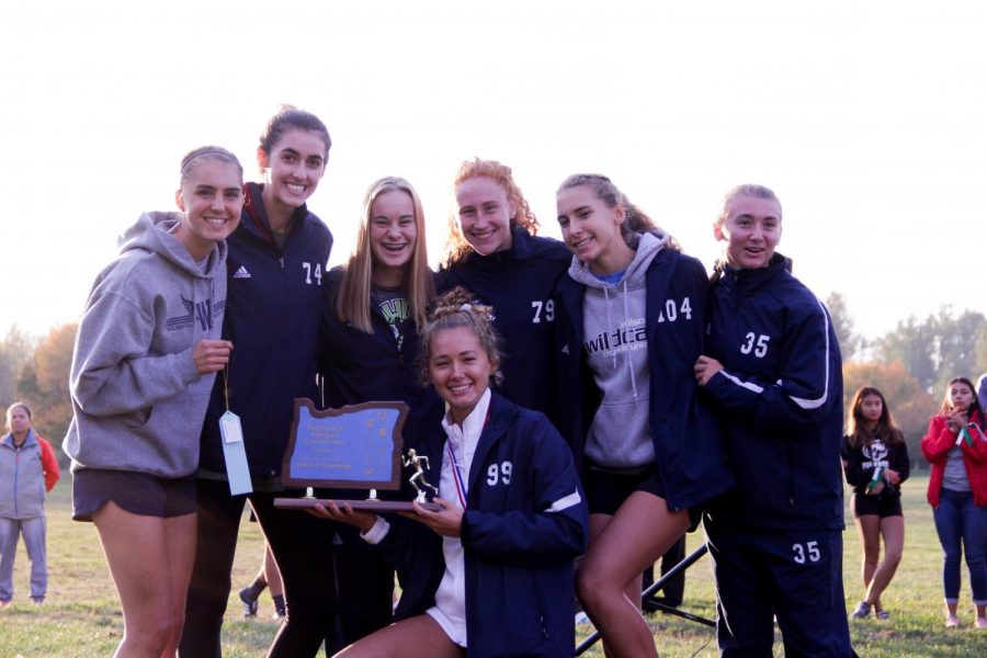 The Wilsonville High School varsity girls team smile as they hold the winning trophy. Both varsity teams qualified for state. 