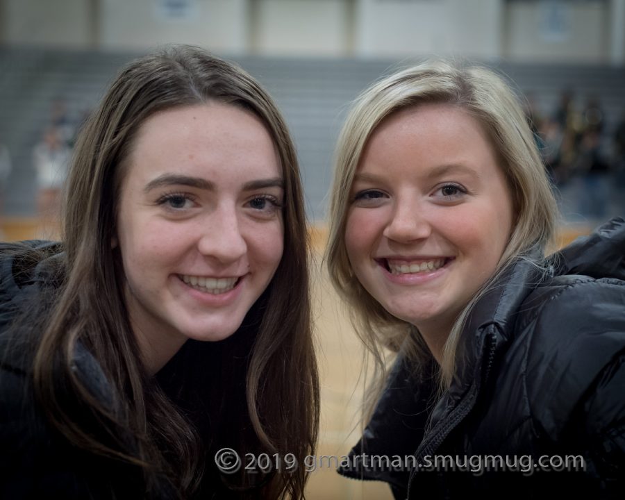 Injured senior players Reese Timm and Emily Scanlan cheer their team on from the bench. 