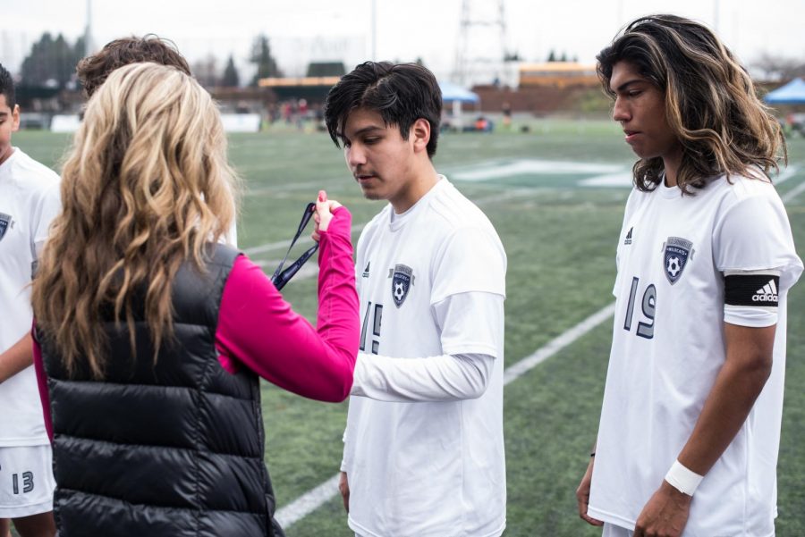 Senior defender Daniel Espinoza receives his medal after the game.