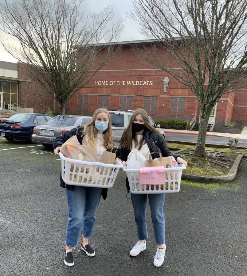 Natalie Opager and Halle Isaak are holding some of the donations dropped off at the High School. The donated goods will be given to Rose Haven.