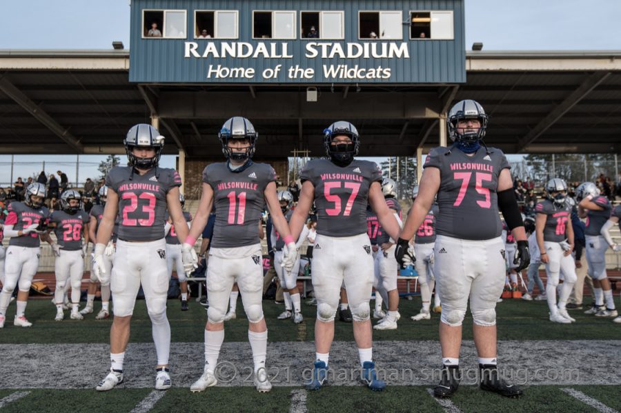 Seniors Payton Dart, Colby Guenther, Jake Moore, and Aaron Wilcox walking to the middle of the field for their last coin toss on senior night.