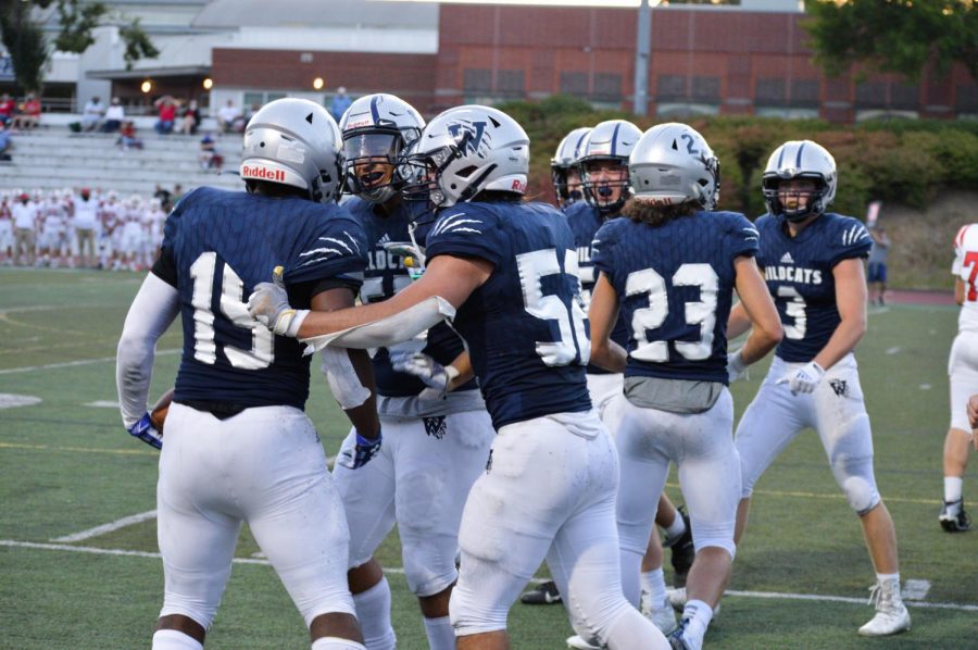 Numerous Wildcats celebrate with Jay Rummel-West after a big play for Wilsonville.