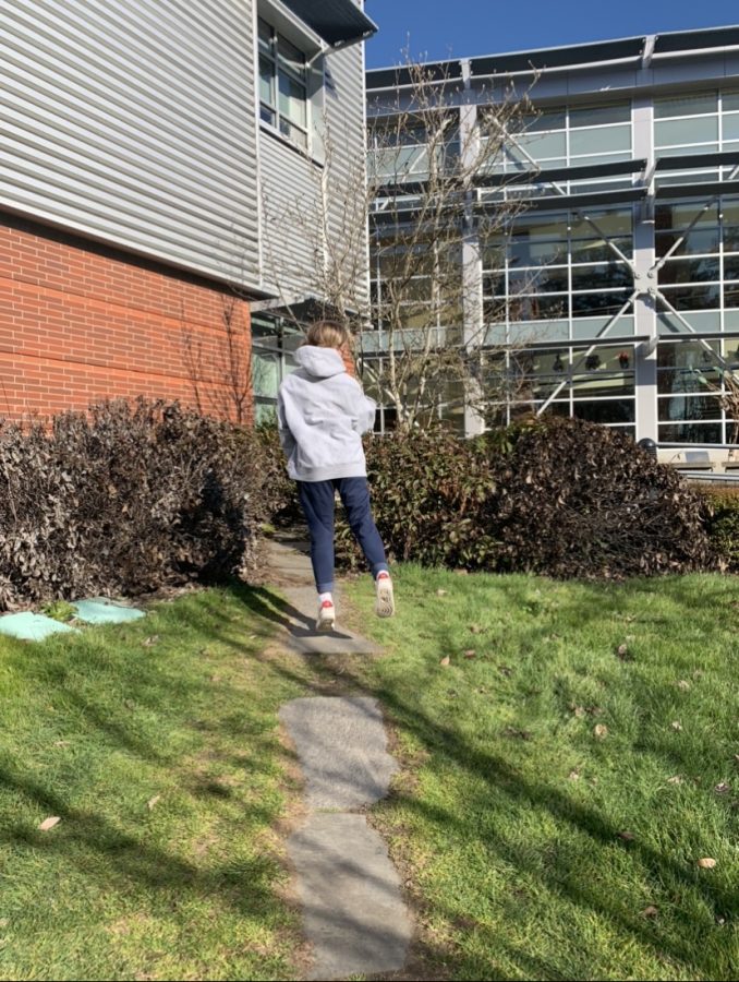 Fiona Dunn, junior, jumping for joy outside of Wilsonville Highschool. The sun was lovely, but don't let it decide you. It was 34 degrees outside.