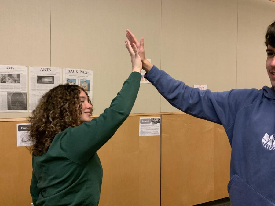 Two students High fiving. School and community is about supporting eachother, this is exactly what these two students are doing.