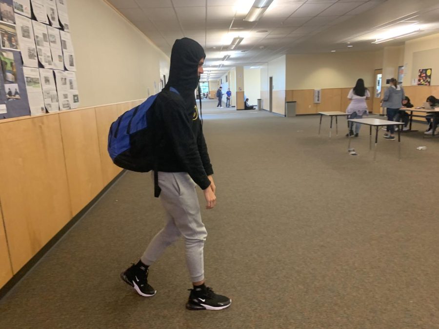 Connor Larsen walking down the hallway. He is trying to get done with the school day. 