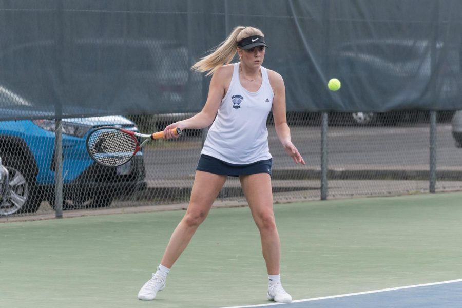 Senior Megan Eagles hits a forehand in the match against Southridge. Eagles and her doubles partner won this match, assisting the team in an overall win.