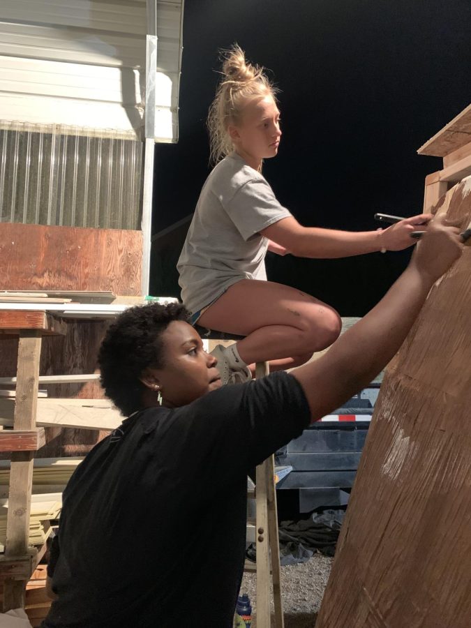 Seniors Lidya Harms and Tatum Hagen hard at work on the senior float. This years theme is Iconic movies.