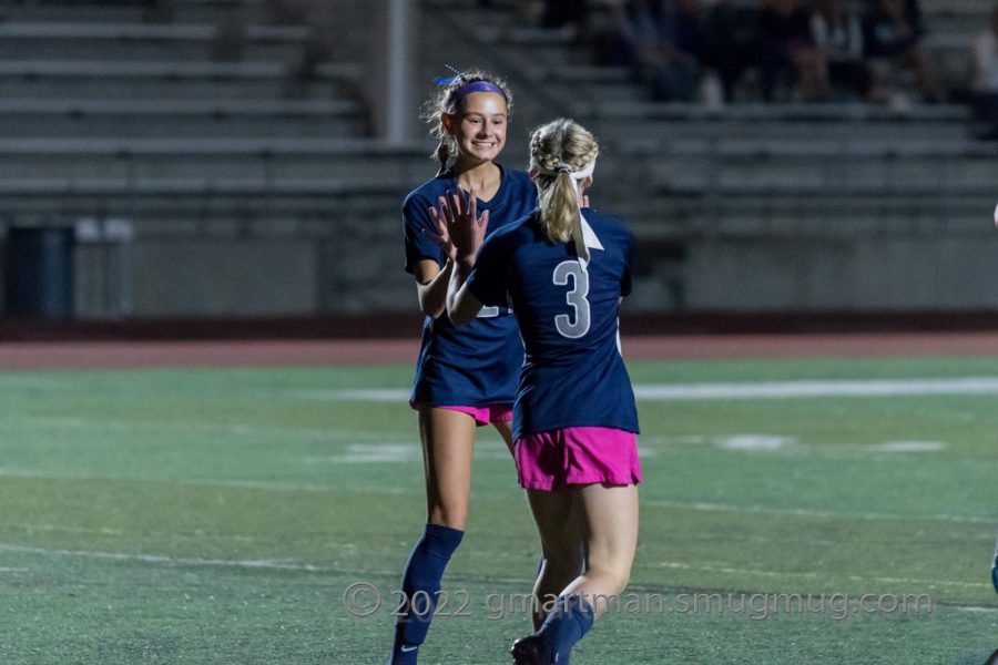 Junior Caroline de la Motte and freshman Camryn Schaan celebrate after a goal. Wilsonville easily scored 8 goals on Hood River. 