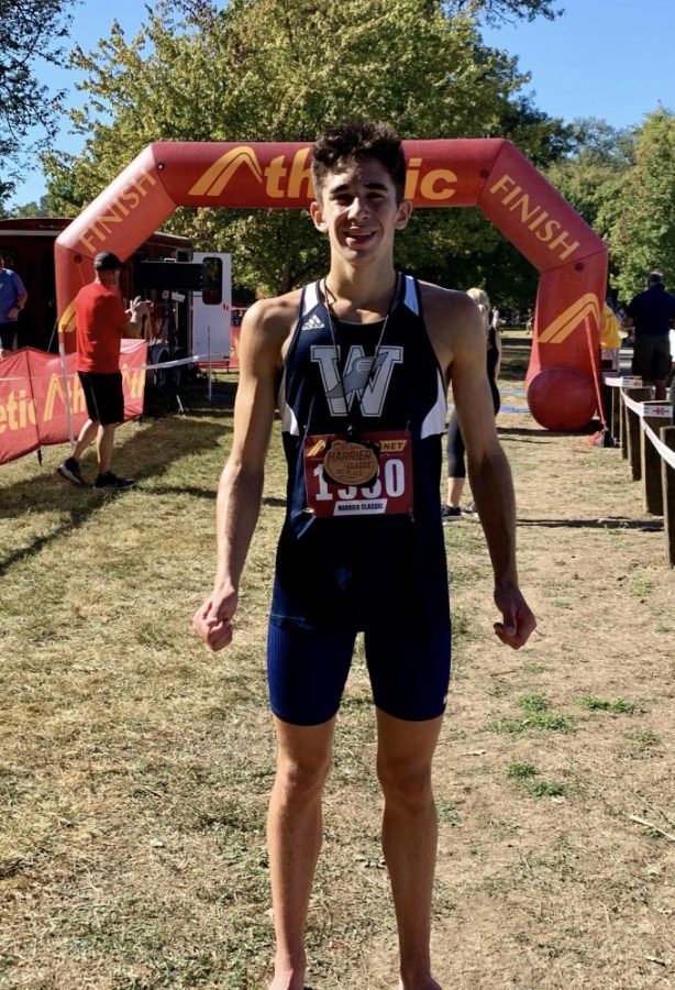 Carter Cutting stands in front of the finish line after placing first in the boys varsity division. This is Cutting's first season on the Wilsonville team after moving back to Oregon this past summer.