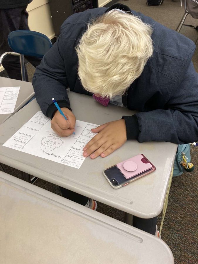 Maximus, a junior, resists the urge to get on his phone. Sometimes just have it out on the desk can be a distraction.