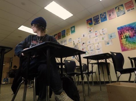 Sam, senior, can be seen listening to music. He will continue to listen while talking with fellow classmates.