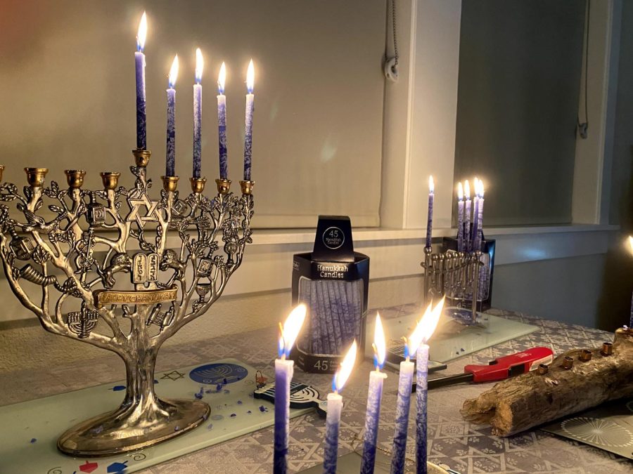 Dena Kaufman shows her family's menorahs with the candles lit. The candles are lit for the fourth night of Hanukkah.