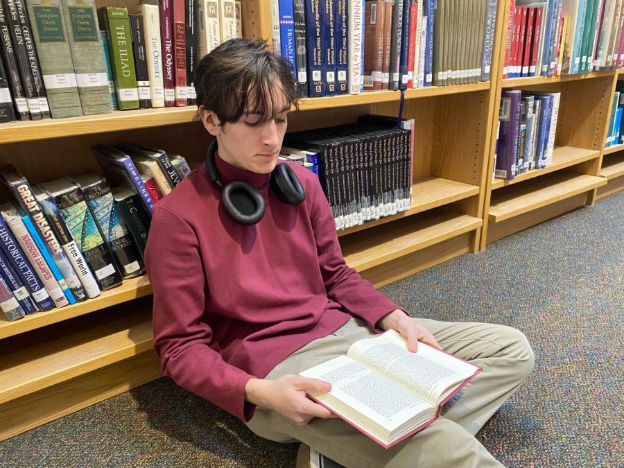 Student Ethan Kessler is calmly reading in his book while sitting in Wilsonville High School's library. Hopefully more students will join him and indulge their love of reading. 