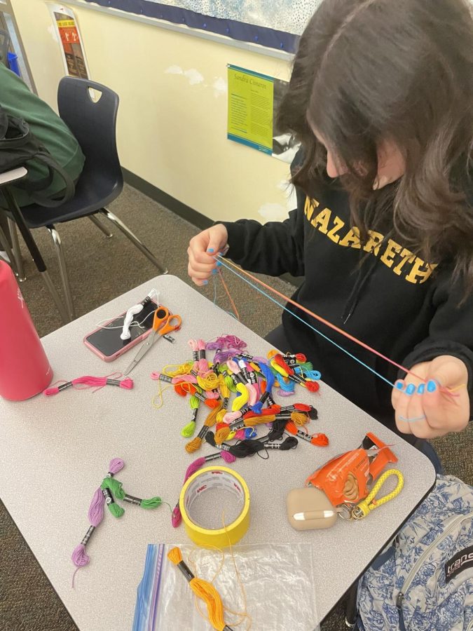 Senior Claudia Molatore makes bracelets during her AP Lit class after the AP test. 