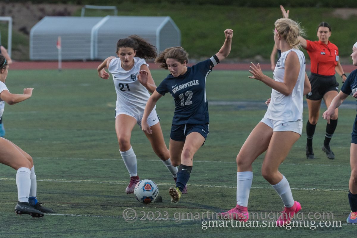 Senior Kenley Whittaker attempts a shot on goal vs. Lake Oswego. Photo provided by Greg Artman.